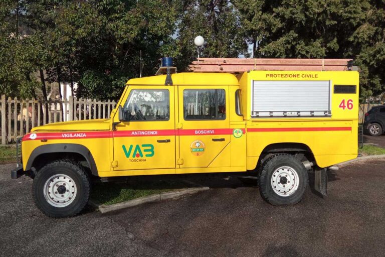 Vista laterale di automezzi pickup Land Rover giallo Protezione Civile