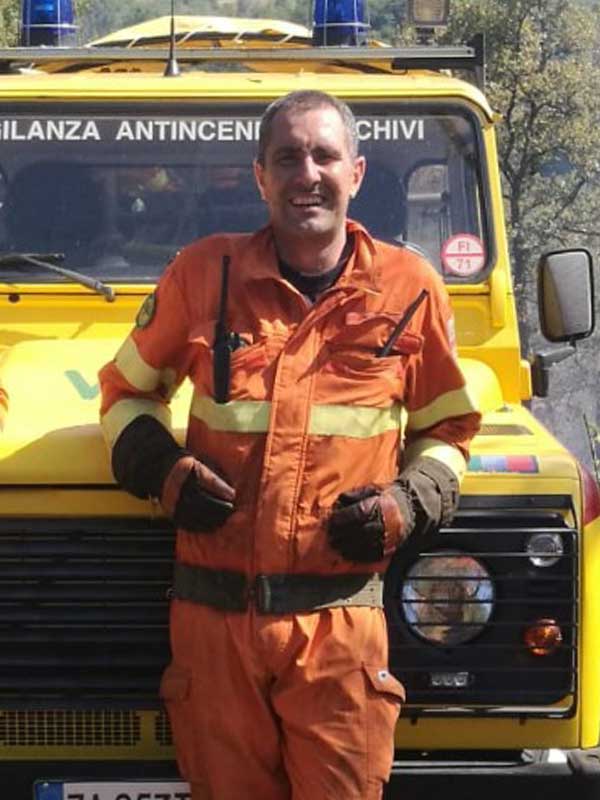 contattaci Persona con tuta arancione appoggiata su auto gialla Protezione Civile